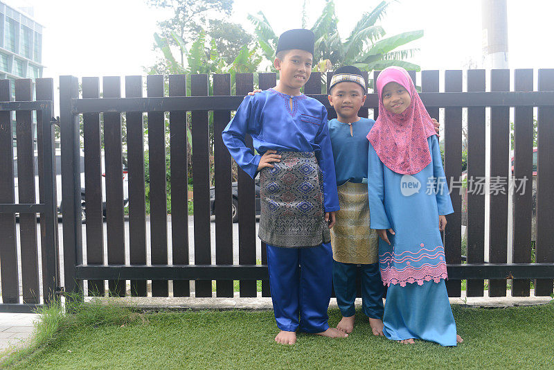 在开斋节期间，马来西亚儿童在家里穿着传统服装