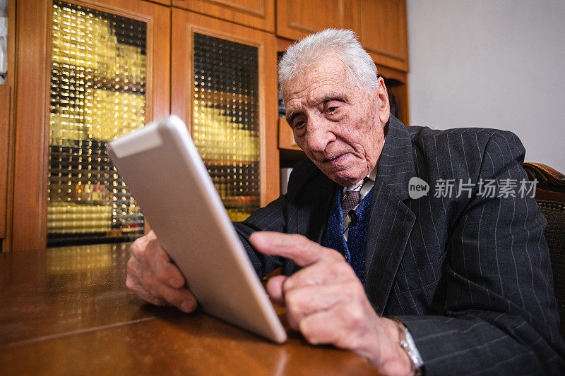 老人在用平板电脑。