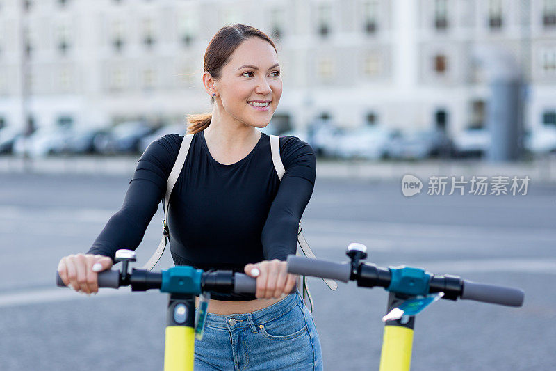 一名女子用手机应用程序解锁一辆电动滑板车