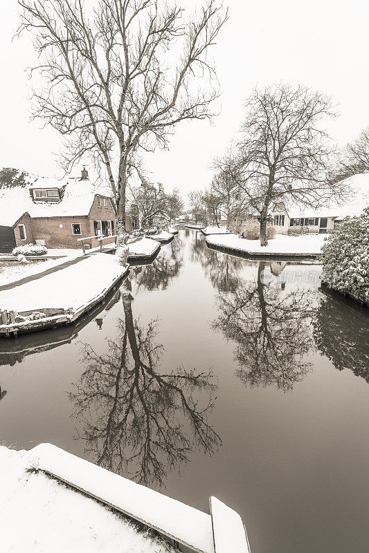 在一个寒冷但美丽而平静的冬天，Giethoorn村附近的Dwarsgracht有积雪的运河