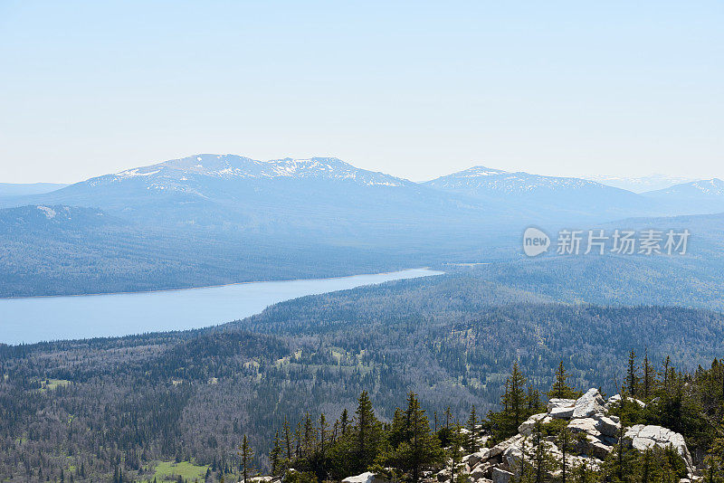 自然美。广阔的林地，岩石，河流和高雪山在远处的风景航拍图像。国家公园，乌拉尔，俄罗斯