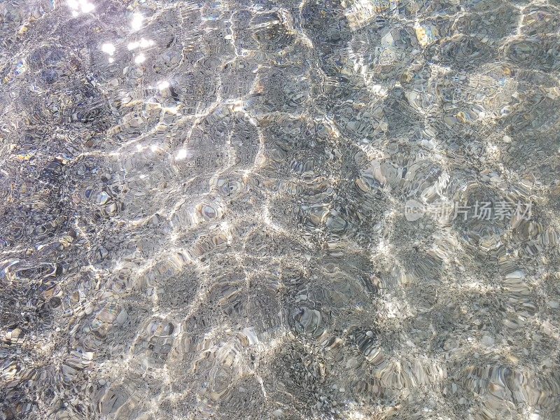 波光粼粼的阳光下的水波纹图案在浅海水水平的看法