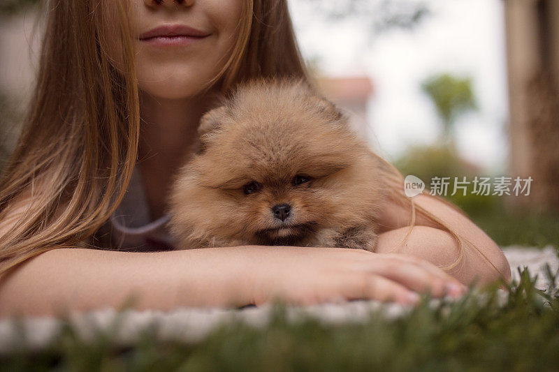 小女孩在后院里拥抱小狗