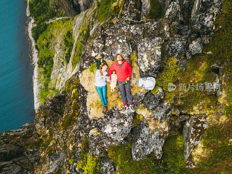 一对夫妇和狗在山顶休息，感受自由和幸福