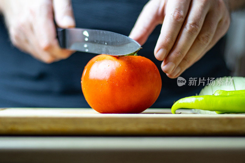 男厨师正在砧板上切西红柿