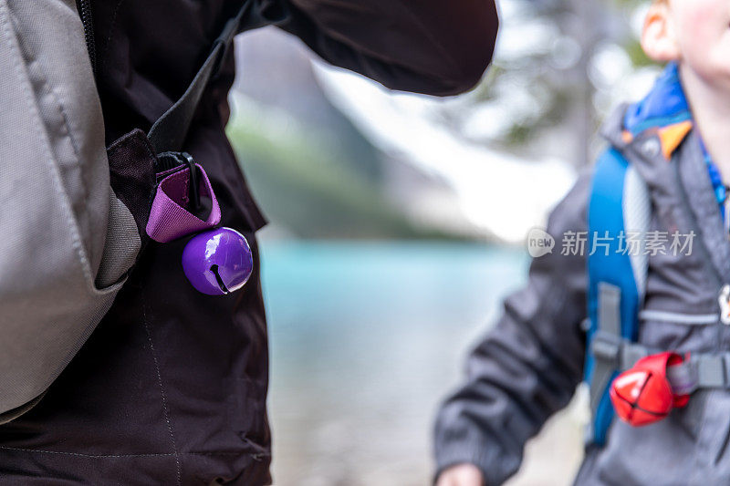 夏天，母亲和儿子在冰碛湖小径上散步，为了安全，他们都戴着一个熊铃