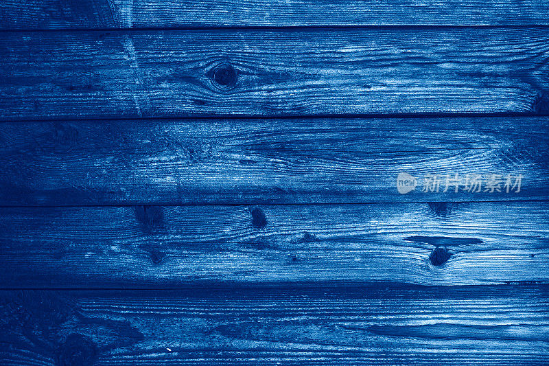 木质纹理配以天然木纹图案进行设计和装饰。深棕色木材背景。趋势颜色经典蓝色。2020年的颜色。今年的主要趋势。蓝色创意着色。
