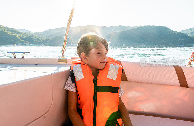 小男孩在船上看着湖面