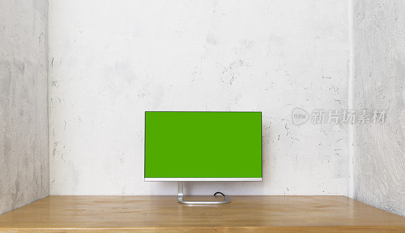 绿色屏幕的电脑显示器放在木桌上