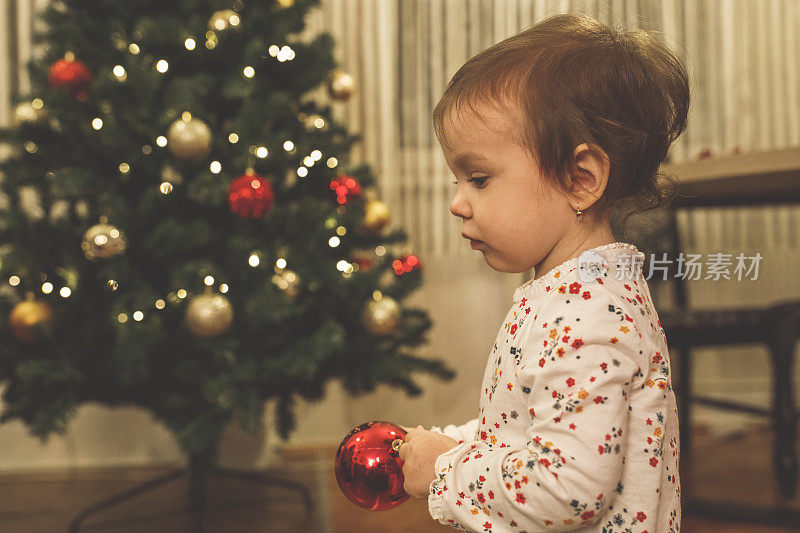 可爱的小女孩在玩圣诞装饰品