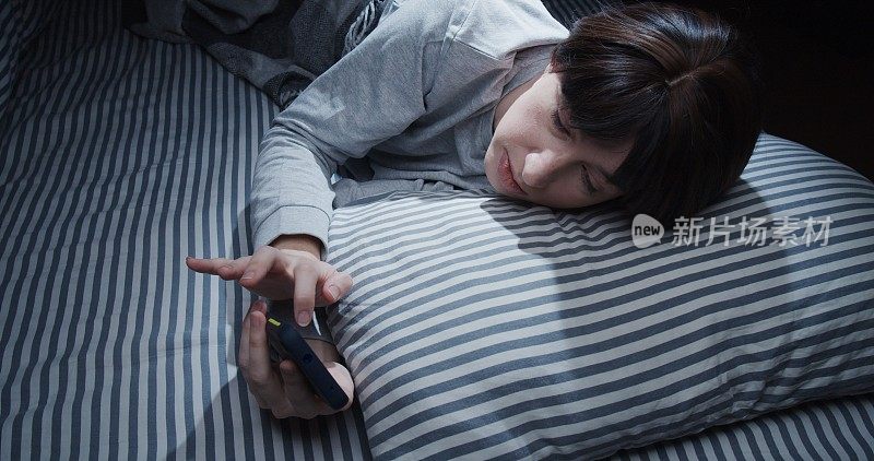 成熟的女人在床上使用智能手机