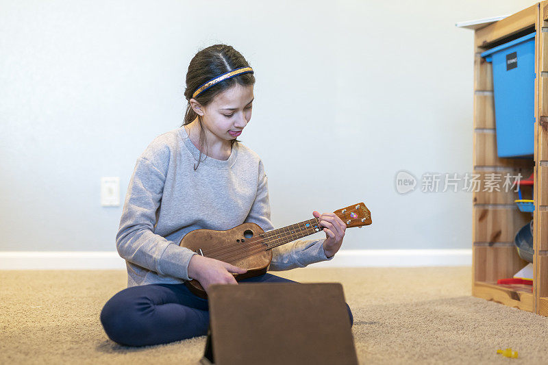 十多岁的女孩用平板电脑上音乐课