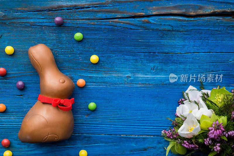 巧克力复活节兔子和糖果的木制背景。