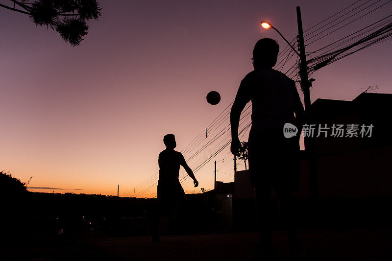 库里提巴，Paraná，巴西——两个男孩在街上踢足球。