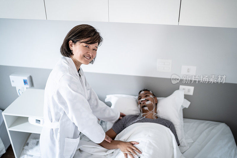 医生的肖像检查在一个医疗诊所的病床上的病人