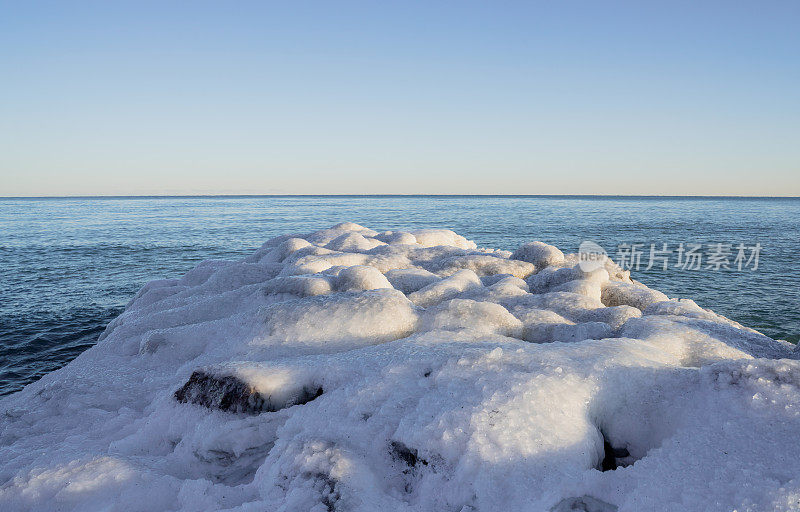 晴朗的日子里，空荡荡的海岸和冰雪覆盖的海洋里的码头