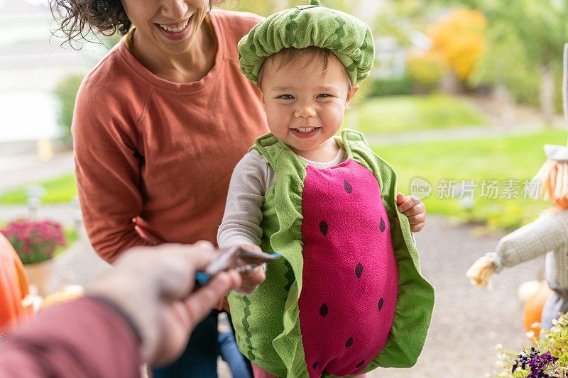 可爱的小女孩在万圣节玩“不给糖就捣蛋”的游戏