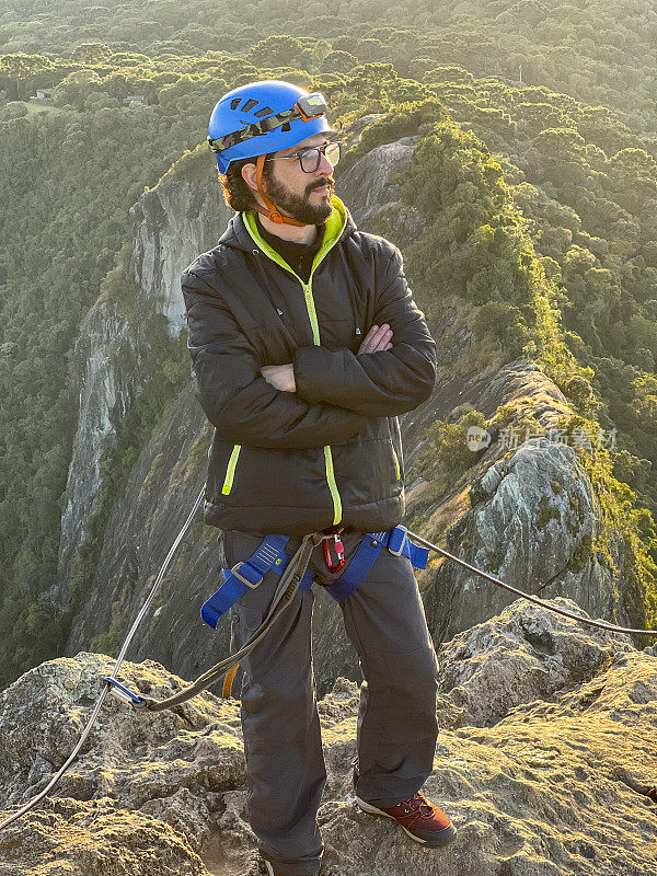 年轻的拉丁男子在山顶登山。极限运动的概念