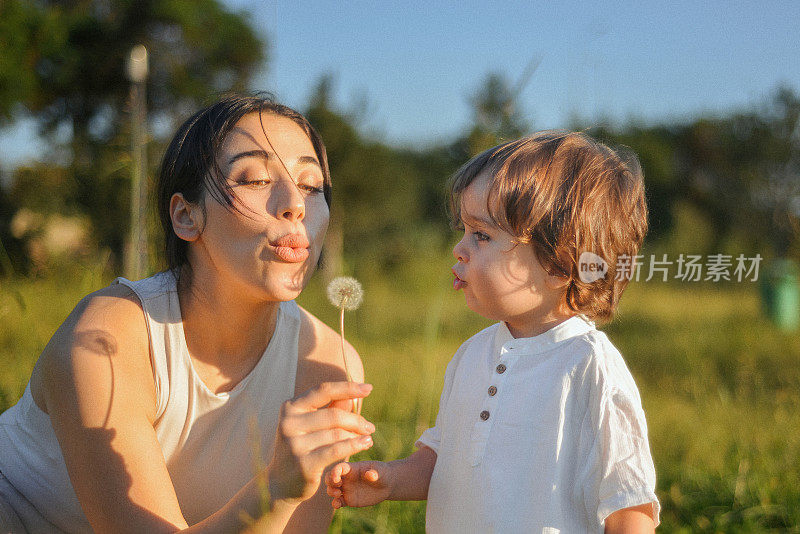 一个可爱的小男孩和他的妈妈在公园玩耍的肖像