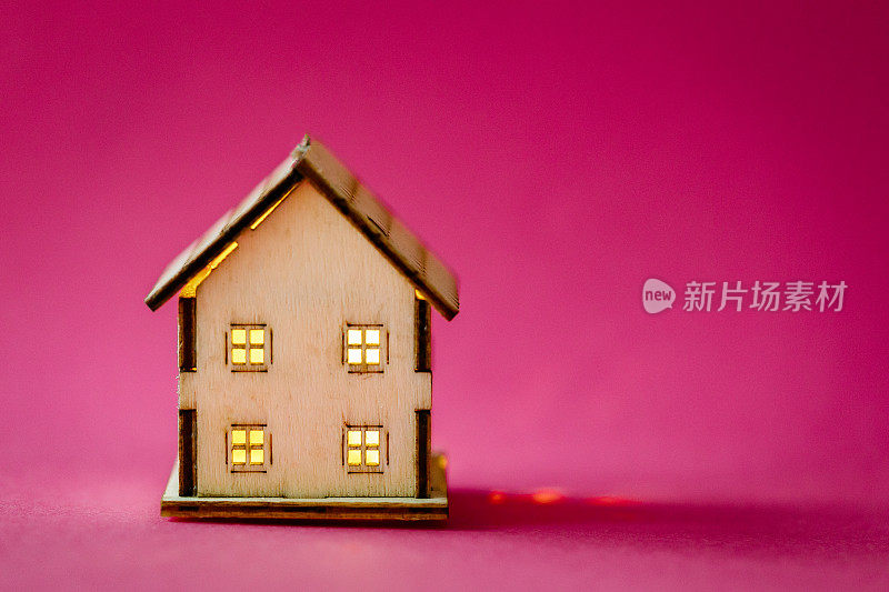 粉色背景的木制模型房子
