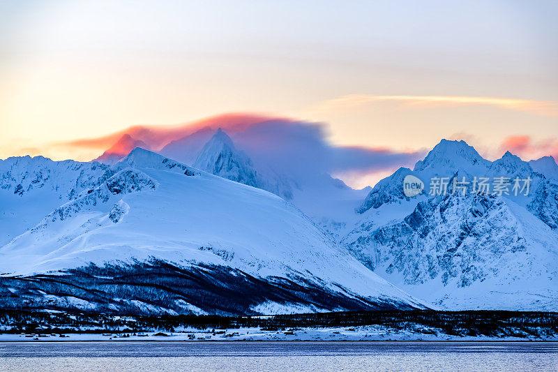 在白雪皑皑的挪威山脉，蓝色的冬日日出