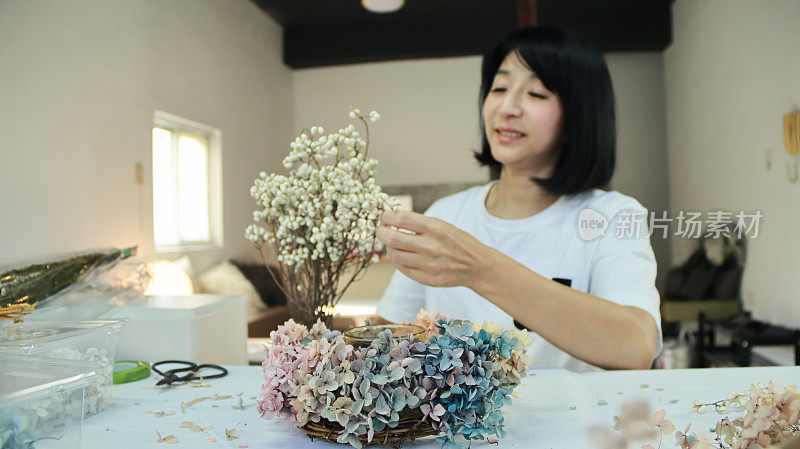 一位女花艺教师正在用绣球花制作花圈