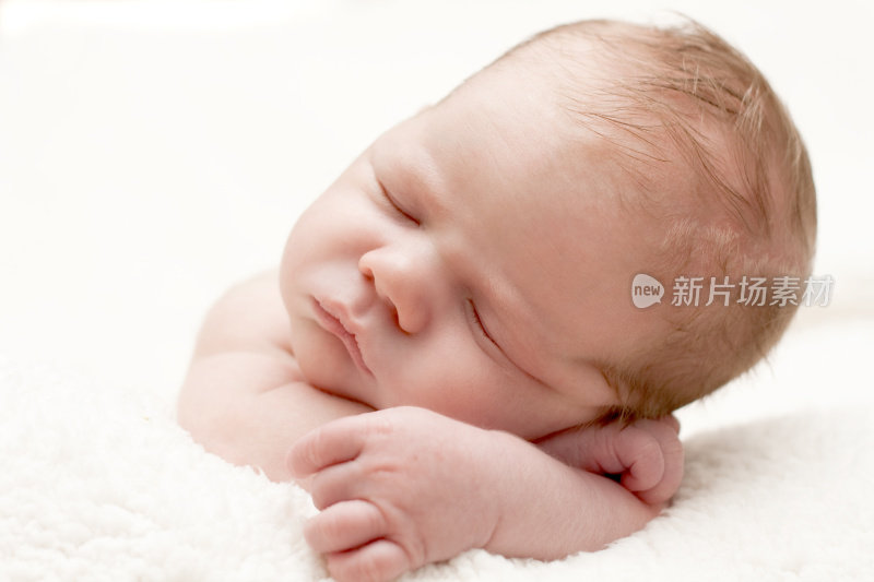 刚出生的婴儿睡在一条白毛巾上