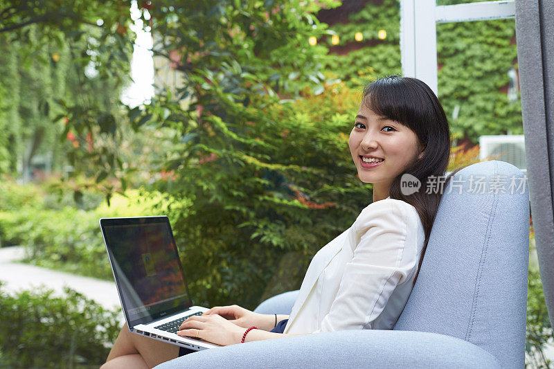 在办公室用笔记本电脑工作的亚洲商务女性