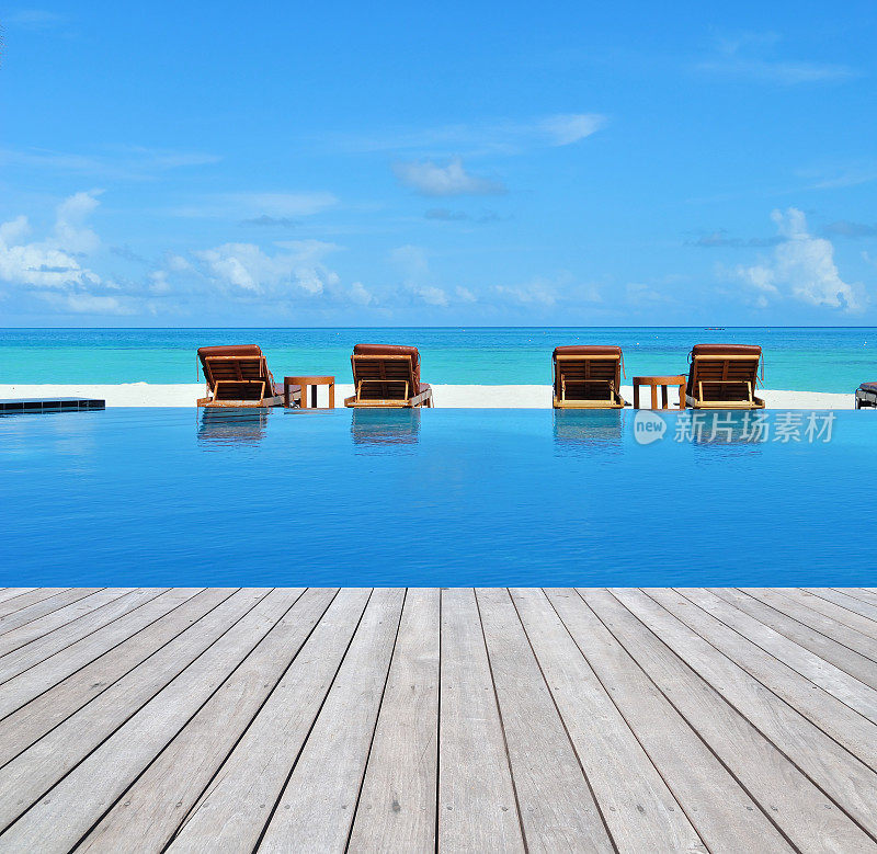 热带海滩度假村游泳池旁的木板路