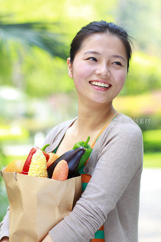 快乐年轻的亚洲女人拿着购物袋