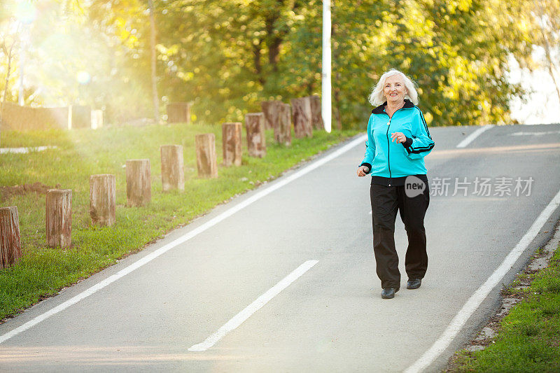 老年妇女在人行道慢跑