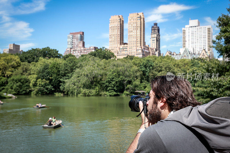 男摄影师在纽约中央公园拍照