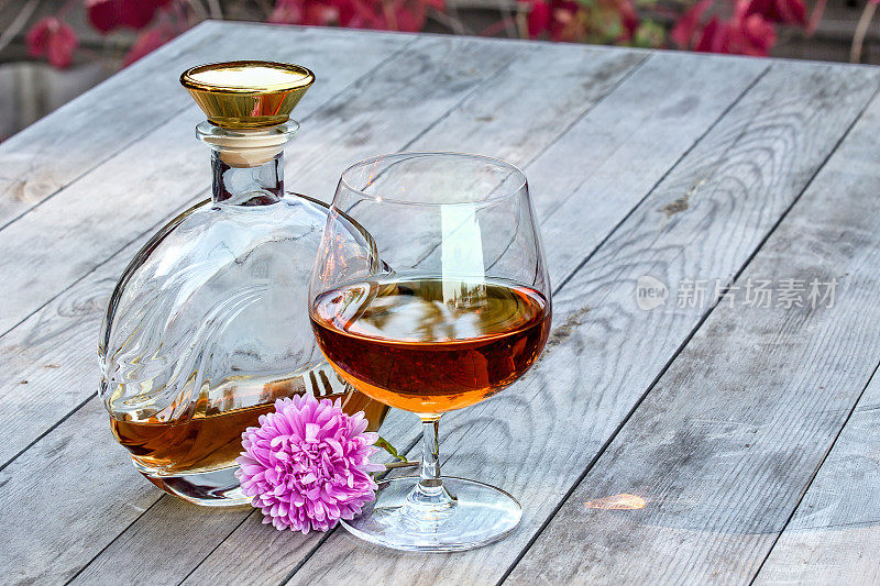 花园里的桌上放着鲜花和酒瓶白兰地