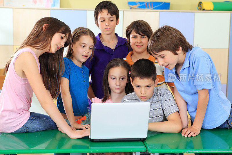 孩子们在教室里看笔记本电脑