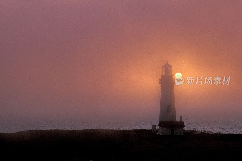 太阳在俄勒冈州海岸的Yaquina头灯塔后面升起