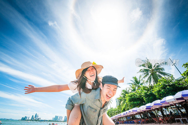 男人在海滩上让女人骑在背上。