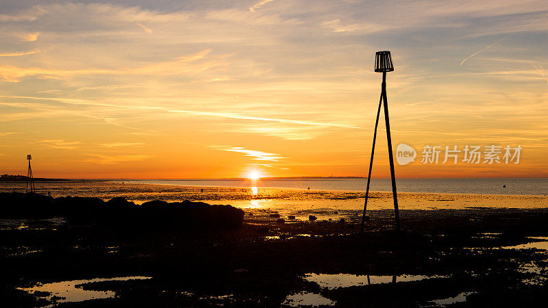 日落时分，赫恩湾的潮汐标志映出海滩上的剪影