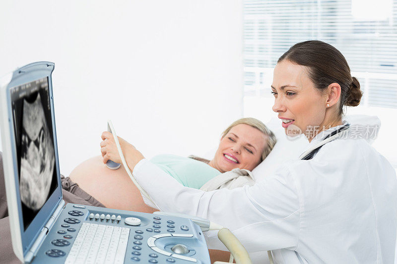 愉快的怀孕金发美女正在做超声波扫描