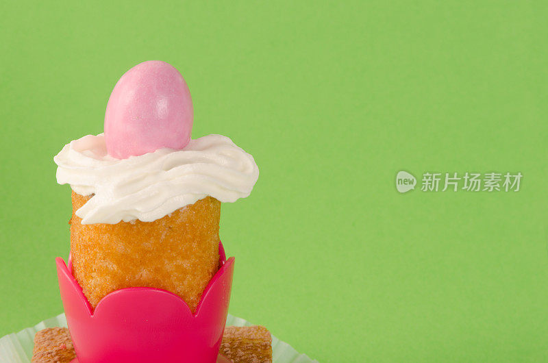 迷你蛋糕与粉色复活节彩蛋在绿色的背景