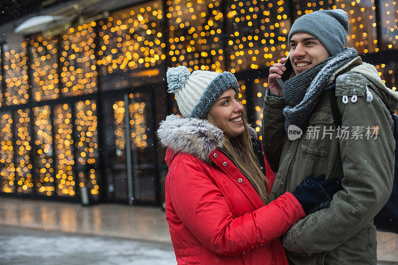 年轻夫妇在城市街道上使用手机