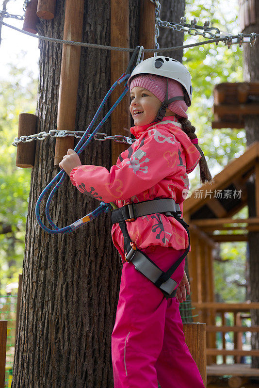 十几岁的女孩有乐趣在绳索课程冒险公园。Zipline为孩子。