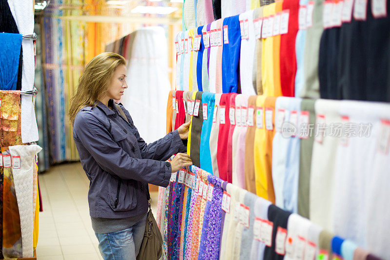 女人在商店里买布料