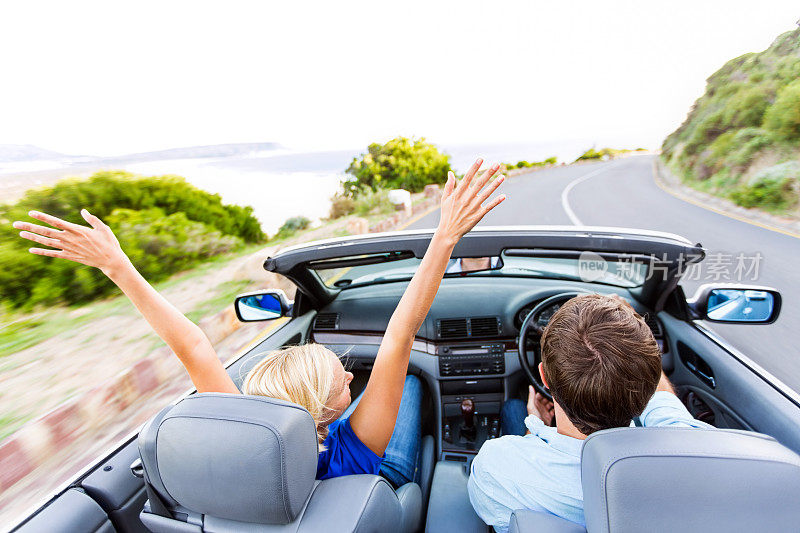 快乐的女人享受公路旅行与男人开车