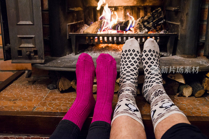 在壁炉前，一对穿着袜子的情侣的浪漫腿