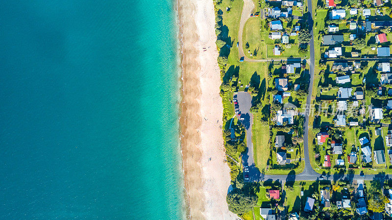鸟瞰图在一个阳光明媚的海滩上的小郊区。科罗曼德尔半岛，新西兰