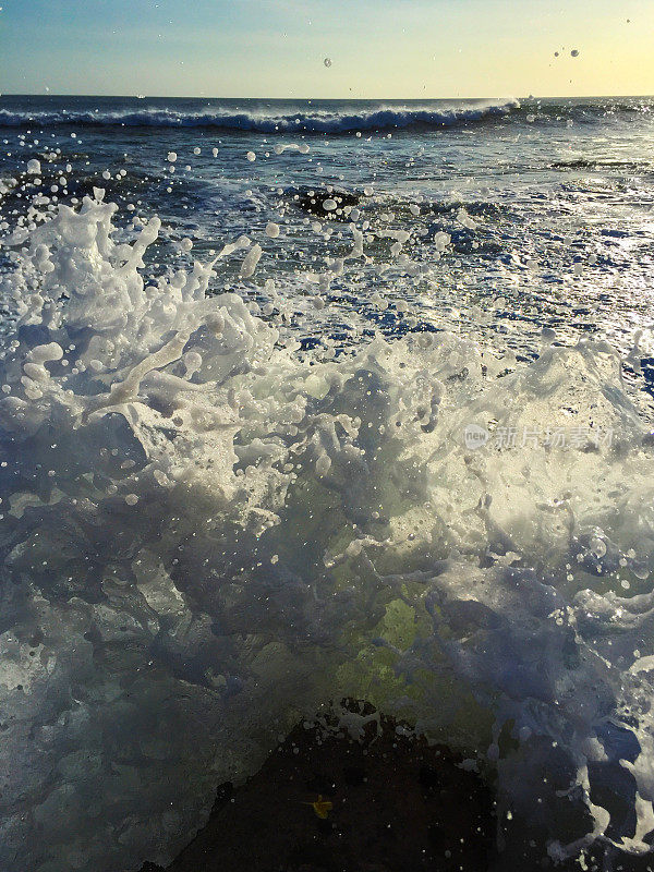 巨浪溅过海滩岩石。巨大的水飞溅。