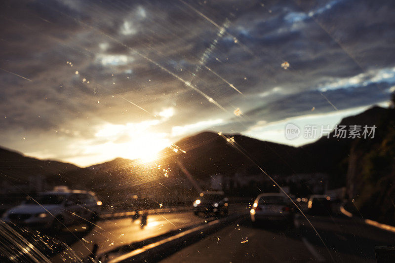 开车在路上透过挡风玻璃看日落