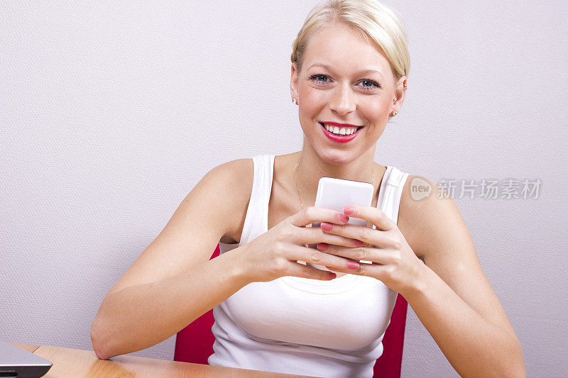 年轻的金发女人拿着智能手机