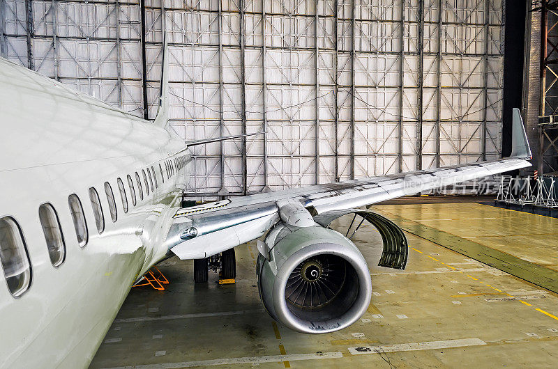 查看机翼和发动机的飞机在机库修理。