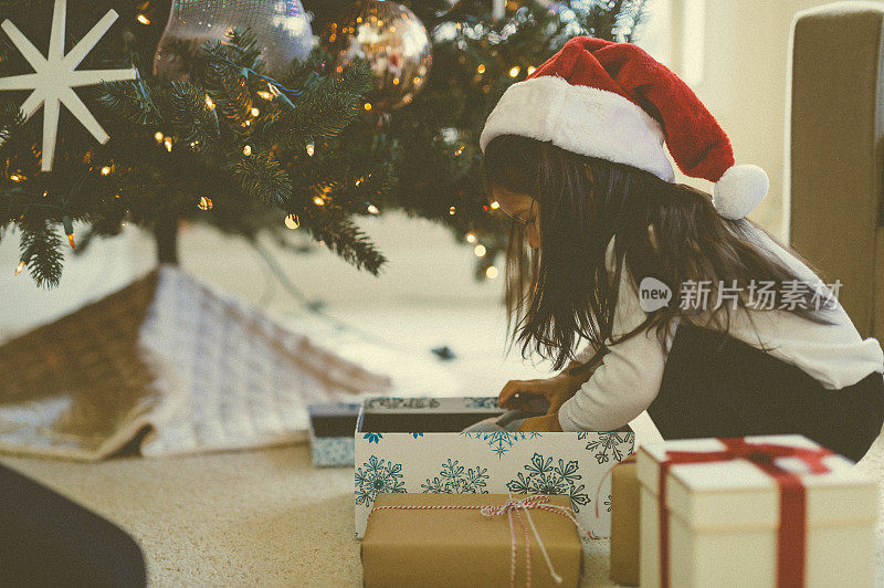 小女孩在圣诞树前玩积木